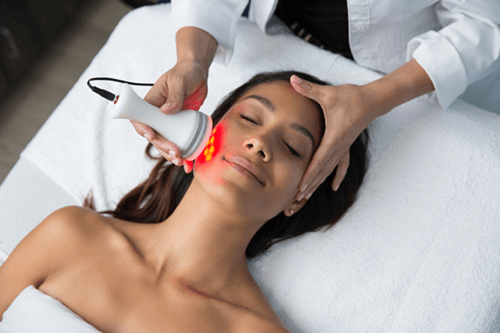 A relaxed woman receives LED Skin Phototherapy treatment.